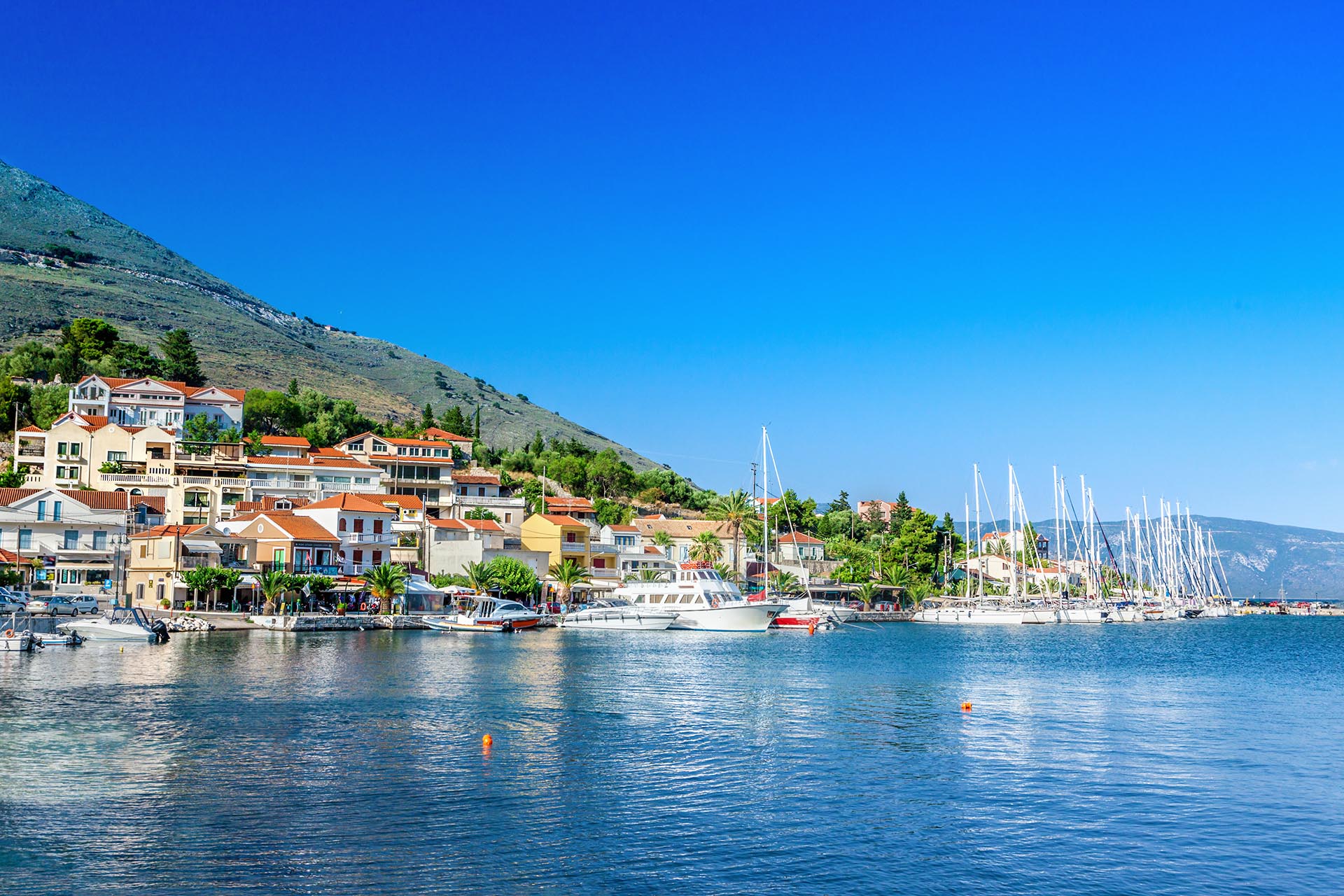 Agia Efimia waterfront with moored yachts and mountains in the distance, Kefalonia, Greek Islands